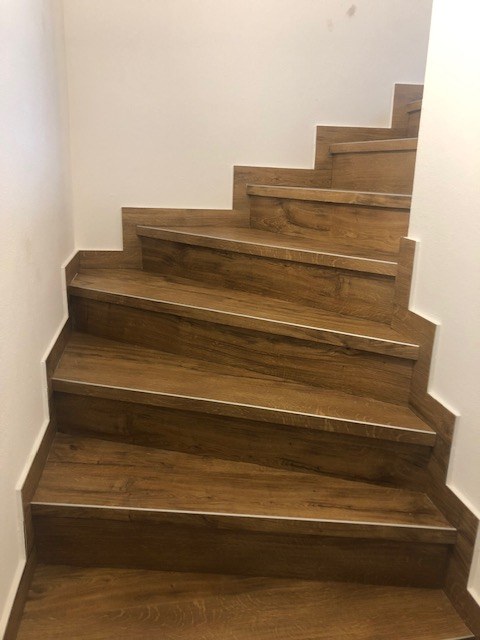 Mit Holzoptik-Belag verkleidete Treppe nach Sanierung